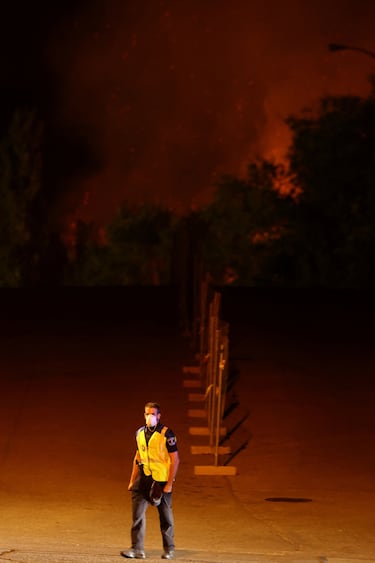 Un agente de policía camina durante un incendio forestal en Tres Cantos, cerca de Madrid, España.