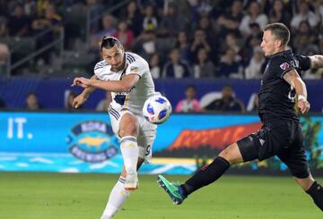 Jul 4, 2018; Carson, CA, USA; LA Galaxy forward Zlatan Ibrahimovic (9) kicks against D.C. United defender Frederic Brillant (13) in the second half at StubHub Center. The teams played to a 2-2 tie. Mandatory Credit: Kirby Lee-USA TODAY Sports