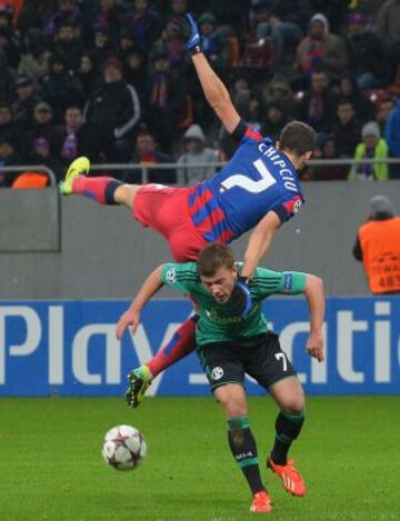 El jugador del Steaua Alexandru Chipciu salta por encima del jugador del Schalke Max Meyer, durante el partido del grupo E de la Liga de Campeones, en el estadio National Arena de Bucarest (Rumania).