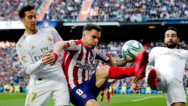 Lucas Vázquez, que entró al descanso, pugna con Saúl en el derbi.