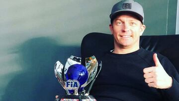 Kimi Raikkonen con su premio de la FIA.