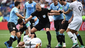 El árbitro argentino Néstor Pitana (C) detiene a los jugadores de Uruguay mientras el delantero francés Kylian Mbappé yace en el suelo durante el partido de cuartos de final del Mundial de Fútbol Rusia 2018 entre Uruguay y Francia en el Estadio Nizhni Nóvgorod en Nizhni Nóvgorod.