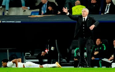 Carlo Ancelotti, entrenador del Real Madrid, da instrucciones con Rodrygo tumbado boca abajo en el césped.