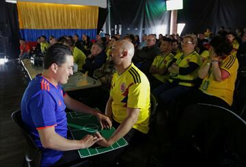 Cesar guía a José Richard a través de sus manos y un tablero.