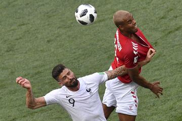 Olivier Giroud salta para robar el balón a Mathias Jorgensen.