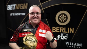 El jugador de dardos inglés Stpehen Bunting posa con el trofeo de campeón de la prueba de la Premier League de Berlín.