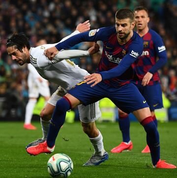 Isco y Piqué pugnan por un balón en el Clásico.