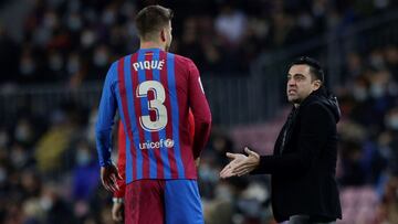 Gerard Piqué y Xavi Hernández, jugador y entrenador del FC Barcelona, hablan durante un partido.