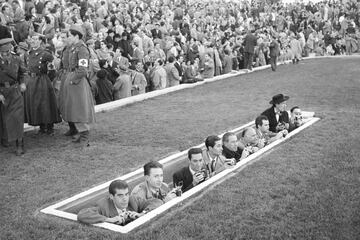 Fotógrafos de prensa situados en un foso durante el partido entre el Atlético de Madrid y el Sevilla C.F., celebrado en el Estadio Metropolitano el 14 de noviembre de 1954.