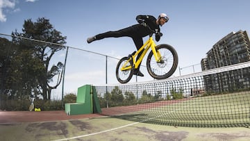 Danny MacAskill montando en su bici de MTB Street trial sobre una red de una pista de tenis en San Francisco (California, Estados Unidos).