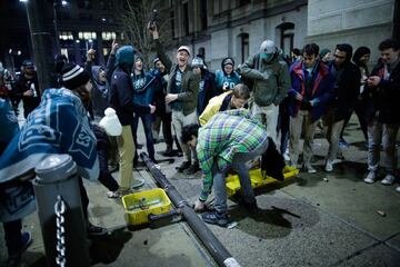 Varios aficionados tumban una señal de tráfico durante los festejos por el título de los Philadelphia Eagles.