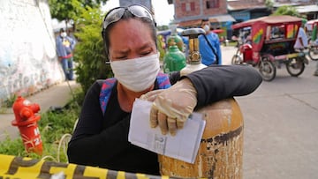 A relative of a COVID-19 patient queues to recharge oxygen tanks for their loved ones at the regional hospital in Iquitos, the largest city in the Peruvian Amazon, Peru on May 14, 2020 during the novel coronavirus pandemic. - People are dying in this impoverished region due to the lack of oxygen. Regional Health Director Carlos Calampa told AFP &quot;We are not only going to need oxygen for Iquitos, but for the peripheryx94. The virus is spreading to the native communities, infected by traveling residents along the vast river basin. (Photo by Cesar VonBancels / AFP)