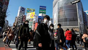 Personas con mascarilla por temor al contagio del coronavirus cruzan en el famoso paso de peatones de Shibuya en Tokio, Japón.