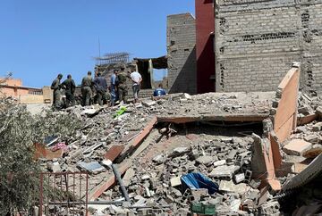 Los rescatistas marroquíes se encuentran entre los escombros de un edificio dañado mientras buscan supervivientes en el pueblo de Amizmiz.