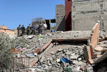 Los rescatistas marroquíes se encuentran entre los escombros de un edificio dañado mientras buscan supervivientes en el pueblo de Amizmiz.