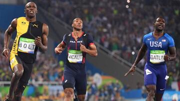 Jamaica's Usain Bolt (L) reacts after he crossed the finish line next to France's Jimmy Vicaut (C) and USA's Justin Gatlin to win the Men's 100m Final during the athletics event at the Rio 2016 Olympic Games at the Olympic Stadium in Rio de Janeiro on August 14, 2016. / AFP PHOTO / OLIVIER MORIN