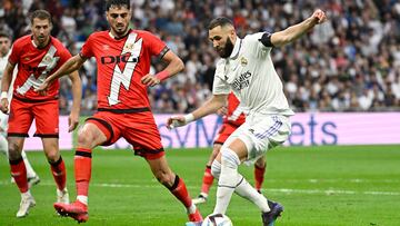 Real Madrid's French forward Karim Benzema vies with Rayo Vallecano's Spanish defender Alejandro Catena (2L) during the Spanish league football match between Real Madrid CF and Rayo Vallecano de Madrid at the Santiago Bernabeu stadium in Madrid on May 24, 2023. Vinicius drew global support after making a stand against racist abuse he received on May 21 from Valencia supporters at their Mestalla stadium. (Photo by JAVIER SORIANO / AFP)