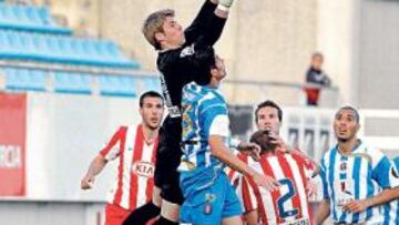 <b>MEDITANDO SU FUTURO. </b>De Gea bloca un balón sobre un jugador del Lorca en un partido con el filial.