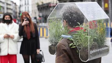 Belgian artist Alain Verschueren wears his "Portable Oasis" while performing in a street, saying he wanted to be in his bubble in the middle of the city, amid the coronavirus disease (COVID-19) outbreak in Brussels, Belgium April 16, 2021. Picture taken April 16, 2021. REUTERS/Yves Herman