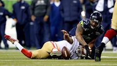 SEATTLE, WA - JANUARY 19:  Quarterback Colin Kaepernick #7 of the San Francisco 49ers looses the ball against defensive end Michael Bennett #72 of the Seattle Seahawks but the 49ers recover in the third quarter during the 2014 NFC Championship at CenturyLink Field on January 19, 2014 in Seattle, Washington.  (Photo by Christian Petersen/Getty Images)