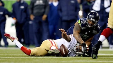 SEATTLE, WA - JANUARY 19:  Quarterback Colin Kaepernick #7 of the San Francisco 49ers looses the ball against defensive end Michael Bennett #72 of the Seattle Seahawks but the 49ers recover in the third quarter during the 2014 NFC Championship at CenturyLink Field on January 19, 2014 in Seattle, Washington.  (Photo by Christian Petersen/Getty Images)