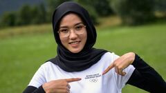 Afghan refugee road cyclist Masomah Ali Zada poses with her t-shirt adorned with the Olympics Rings at the World Cycling Centre (CMC) in Aigle on July 1, 2021 as she prepares to compete at the Tokyo Olympics. - The 24-year-old cyclist had stones thrown at her and was physically attacked in her homeland for daring to don sportswear and ride a bicycle in public. She will compete at the 2020 Games for the Olympic Refugee Team, and feels a duty to represent the 82 million people around the world forced to flee their homes either inside their countries or as refugees. She also sees herself as a representative of women living in repressive societies, and sportswomen who wear a headscarf. (Photo by Fabrice COFFRINI / AFP)