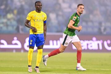 Ettifaq's English midfielder #10 Jordan Henderson runs past Nassr's Senegalese Forward #10 Sadio Mane during the Saudi Pro League football match between Al-Ettifaq and Al-Nassr at the Prince Mohamed bin Fahd Stadium in Dammam on August 14, 2023. (Photo by Ali Alhaji / AFP)