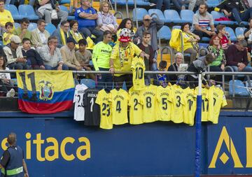 Un grupo de seguidores cuelgan las camisetas del Villarreal con perchas en la grada. 