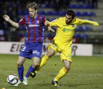 El centrocampista del Eibar Javi Lara con el balón ante el centrocampista del Getafe Pedro León, durante el partido de vuelta de dieciseisavos de final de la Copa del Rey, disputado esta noche en el estadio Ipurua.