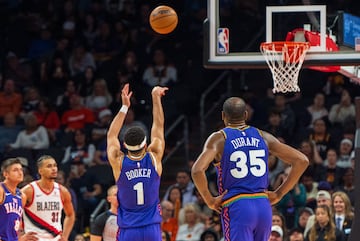 Phoenix Suns forward Kevin Durant (35) watches on as guard Devin Booker (1) shoots his first free throw.