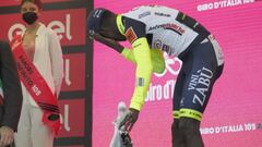 El ciclista eritreo Biniam Girmay se lleva la mano al ojo tras el golpe que recibi&oacute; al descorchar el champ&aacute;n en el podio como ganador de la d&eacute;cima etapa del Giro de Italia en Jesi.