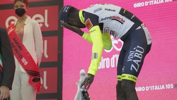 El ciclista eritreo Biniam Girmay se lleva la mano al ojo tras el golpe que recibi&oacute; al descorchar el champ&aacute;n en el podio como ganador de la d&eacute;cima etapa del Giro de Italia en Jesi.