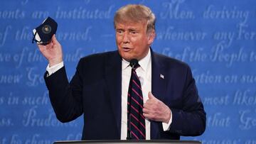 ARCHIVO - En esta fotografía de archivo del 29 de septiembre de 2020, el presidente Donald Trump sostiene su máscara facial durante el primer debate presidencial en la Universidad Case Western y la Clínica Cleveland, en Cleveland, Ohio.