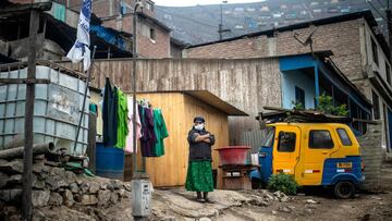 A woman stands outside her house at the Pamplona Alta section -which suffers water shortage- in the southern outskirts of Lima on May 28, 2020, during the new coronavirus pandemic. (Photo by ERNESTO BENAVIDES / AFP)