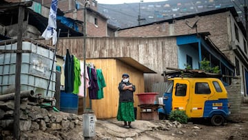 A woman stands outside her house at the Pamplona Alta section -which suffers water shortage- in the southern outskirts of Lima on May 28, 2020, during the new coronavirus pandemic. (Photo by ERNESTO BENAVIDES / AFP)