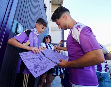 Raúl Moro firma una cartulina a un joven aficionado del Real Valladolid.