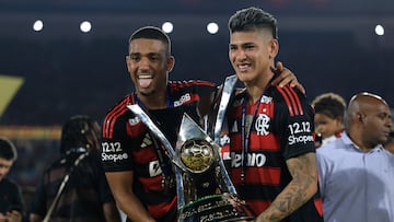 RIO DE JANEIRO, BRAZIL - DECEMBER 03: Wallace Yan and Jorge Carrascal of Flamengo celebrate with the trophy after winning the championship following the Brasileirao 2025 match between Flamengo and Ceara at Maracana Stadium on December 03, 2025 in Rio de Janeiro, Brazil. (Photo by Buda Mendes/Getty Images)