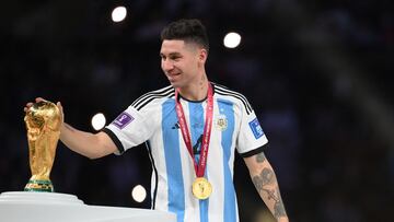 Argentina's defender #04 Gonzalo Montiel touches the World Cup trophy as the team receives their gold medals during the Qatar 2022 World Cup trophy ceremony after the football final match between Argentina and France at Lusail Stadium in Lusail, north of Doha on December 18, 2022. - Argentina won in the penalty shoot-out. (Photo by FRANCK FIFE / AFP)