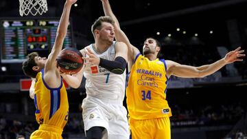 Luka Doncic trata de pasar ante la defensa de Anzejs Pasecniks y Pablo Aguilar.