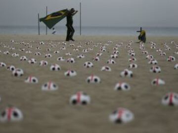 Miembros de la ONG Río de Paz colocan balones de fútbol marcados con cruces rojas como protesta en la playa de Copacabana en Río de Janeiro. La protesta fue un llamado al gobierno para que los servicios de educación, salud pública y para lograr los mismos estándares que los estadios de la Copa Mundial de la FIFA, de acuerdo con la Organización.
