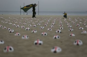 Miembros de la ONG Río de Paz colocan balones de fútbol marcados con cruces rojas como protesta en la playa de Copacabana en Río de Janeiro. La protesta fue un llamado al gobierno para que los servicios de educación, salud pública y para lograr los mismos estándares que los estadios de la Copa Mundial de la FIFA, de acuerdo con la Organización.