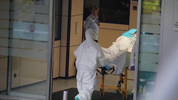 Un sanitario protegido con un traje y guantes de látex, empuja una camilla con una persona sobre ella en el Hospital Universitario Cruces, uno de los hospitales públicos vascos de referencia para infectados por coronavirus, 19 de marzo de 2020.