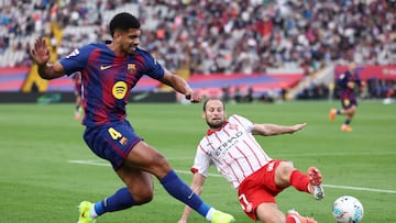 Barcelona's Uruguayan defender #04 Ronald Federico Araujo da Silva fights for the ball with Girona's Dutch defender #17 Daley Blind during the Spanish league football match between FC Barcelona and Girona FC at Estadi Olimpic Lluis Companys in Barcelona on October 18, 2025. (Photo by Josep LAGO / AFP)