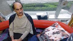 (FILES) In this file photo taken on August 12, 2004 Mehran Karimi Nasseri looks at a poster of the movie inspired by his life, in the terminal 1 of Paris Charles De Gaulle airport. - Mehran Karimi Nasseri, a political refugee who lived over 18 years in Paris' Roissy-Charles de Gaulle airport and inspired director Steven Spielberg's "The Terminal", died, aged 77, at Roissy-Charles de Gaulle airport's terminal 2F, as reported to AFP by airport officials. (Photo by STEPHANE DE SAKUTIN / AFP)