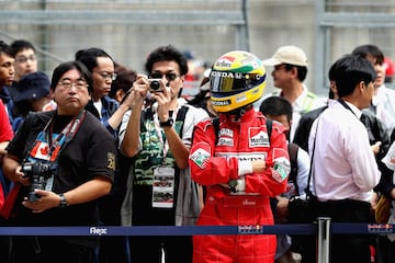 Un aficionado vestido con el mono y casco de Ayrton Senna.