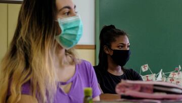 Dos mujeres usan diferentes tipos de mascarillas en un colegio en Canarias, el 4 de junio.