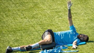 Brais Méndez realiza estiramientos tumbado en el suelo durante un entrenamiento del Celta.