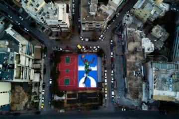 Vista aérea de una cacha de baloncesto en Atenas pintada por el artista callejero Same84 que representa a Giannis Antetokounmpo de los Milwaukee Bucks.