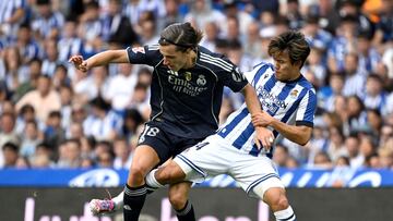 Real Madrid's Spanish defender #18 Alvaro Carreras fights for the ball with Real Sociedad's Japanese forward #14 Takefusa Kubo during the Spanish league football match between Real Sociedad and Real Madrid CF at Anoeta Stadium in San Sebastian on September 13, 2025. (Photo by ANDER GILLENEA / AFP)