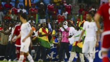 Aficionados Ghana ingresan al campo de juego para huir de proyectiles lanzados por aficionados en las tribunas en el partido entre Ghana y Guinea Ecuatorial.
